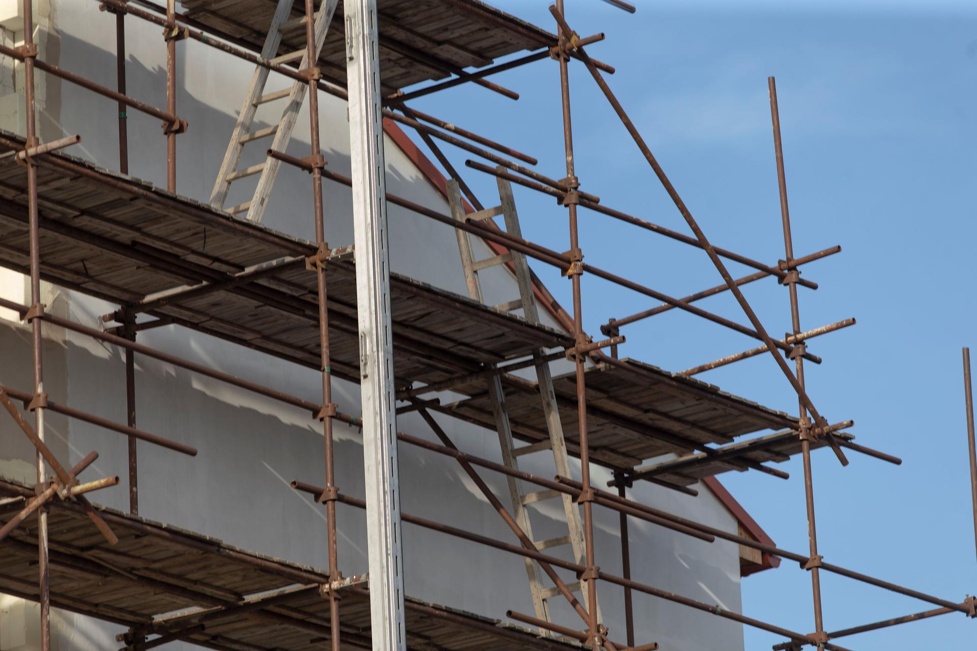 A building under construction has scaffolding on its side