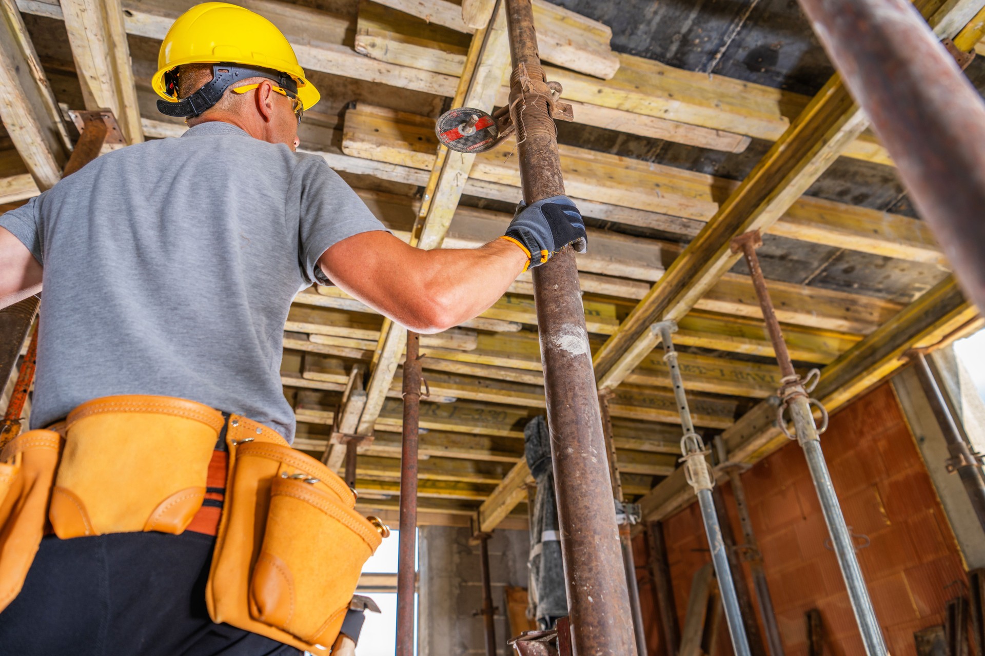 Construction Worker Adjusts Scaffolding at a Job Site During Daylight Hours